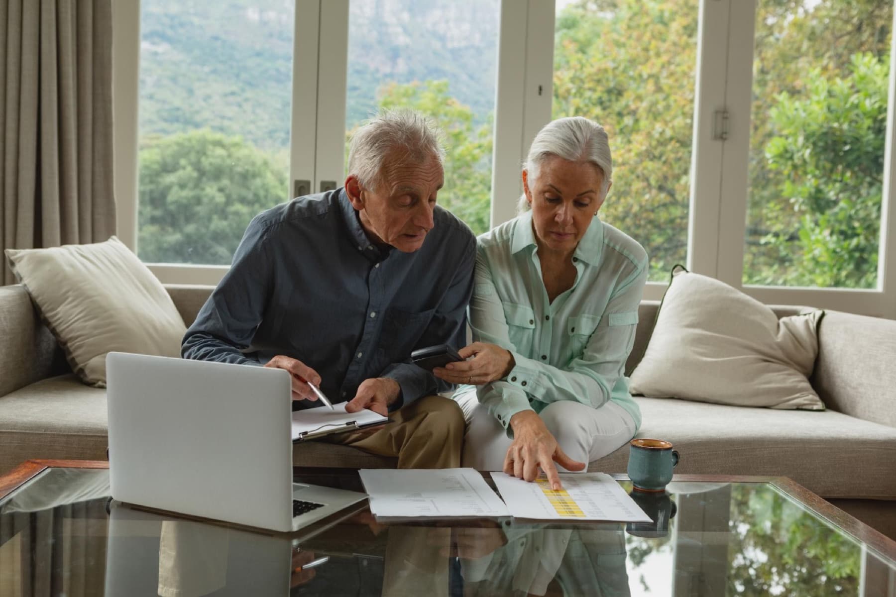 Retired couple reviewing 401(k) contribution limits and retirement paperwork at home.