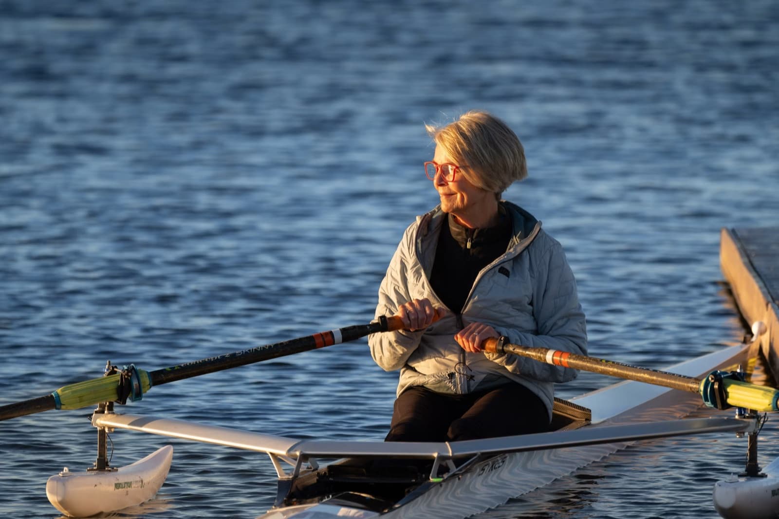 Older woman rowing on the water as a symbol of active retirement planning.