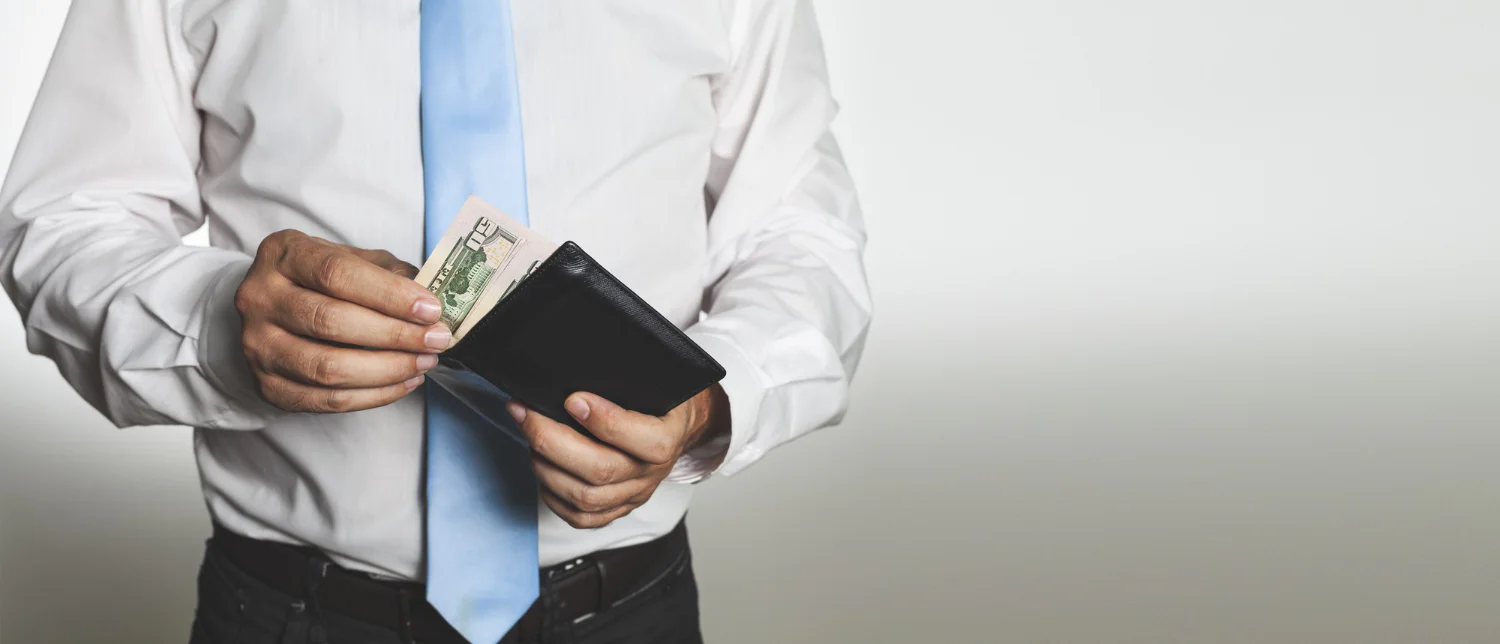 Professional holding a wallet while reviewing the value of a 401(k) employer match.