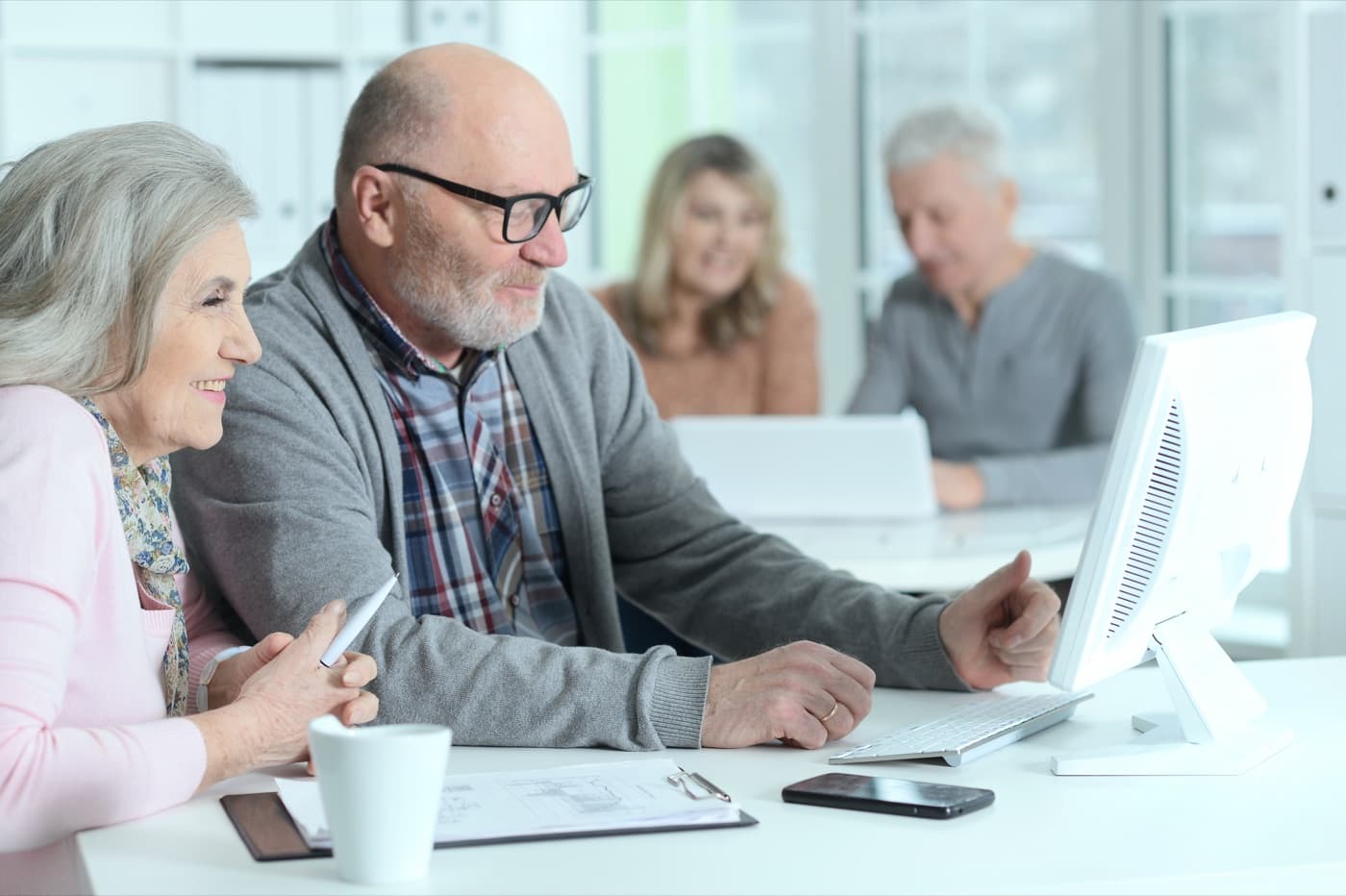 Older adults reviewing workplace retirement planning and 401(k) employer match options.