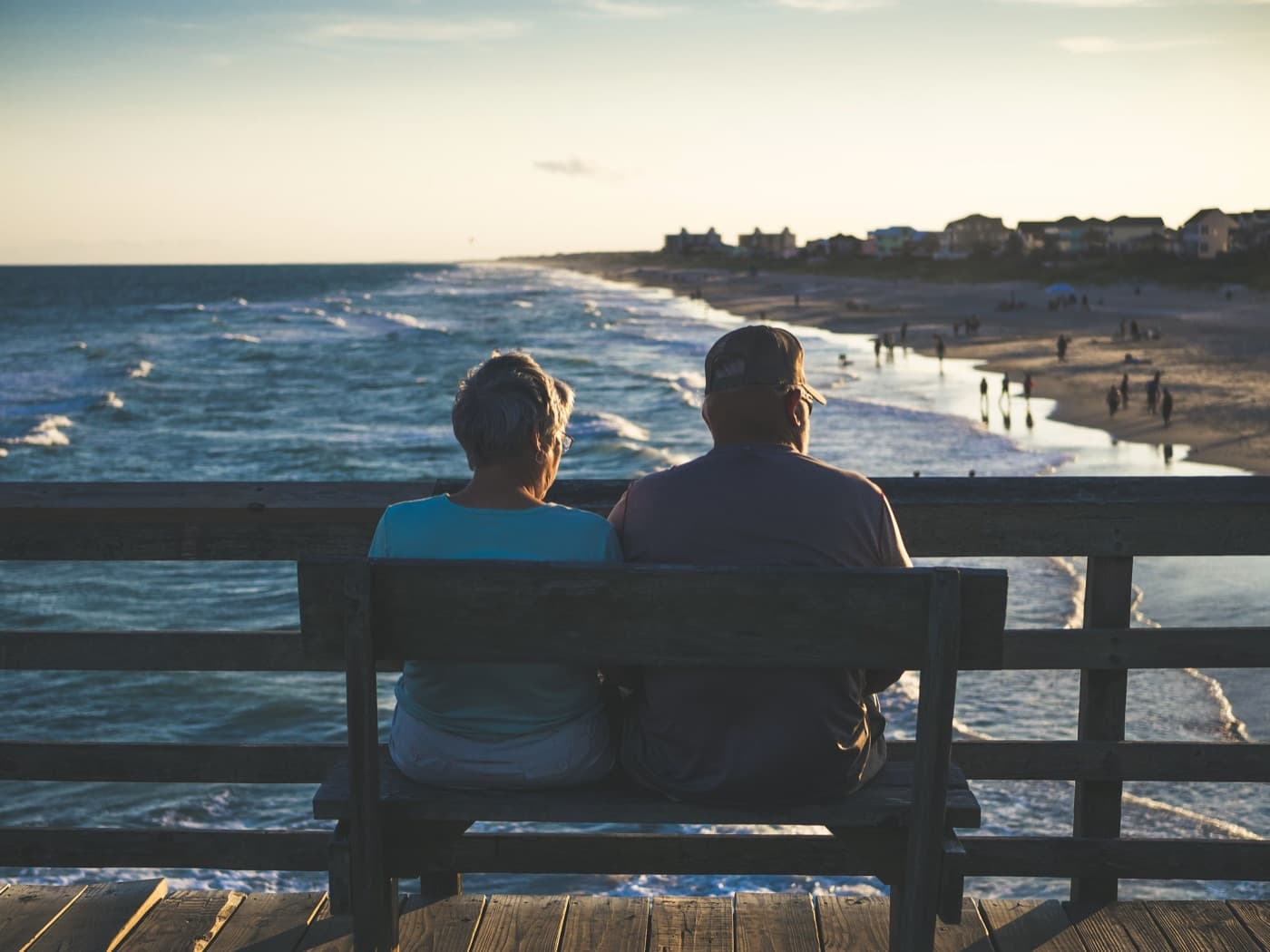 Retired couple sitting by the ocean while planning retirement withdrawals.