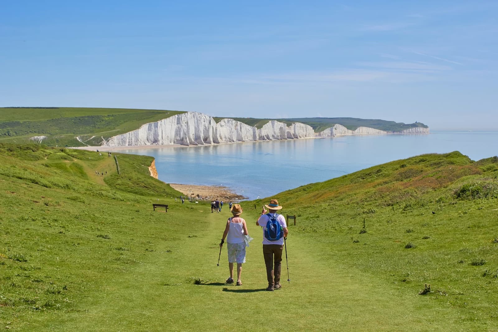 Retired couple walking near coastal cliffs while planning their future.