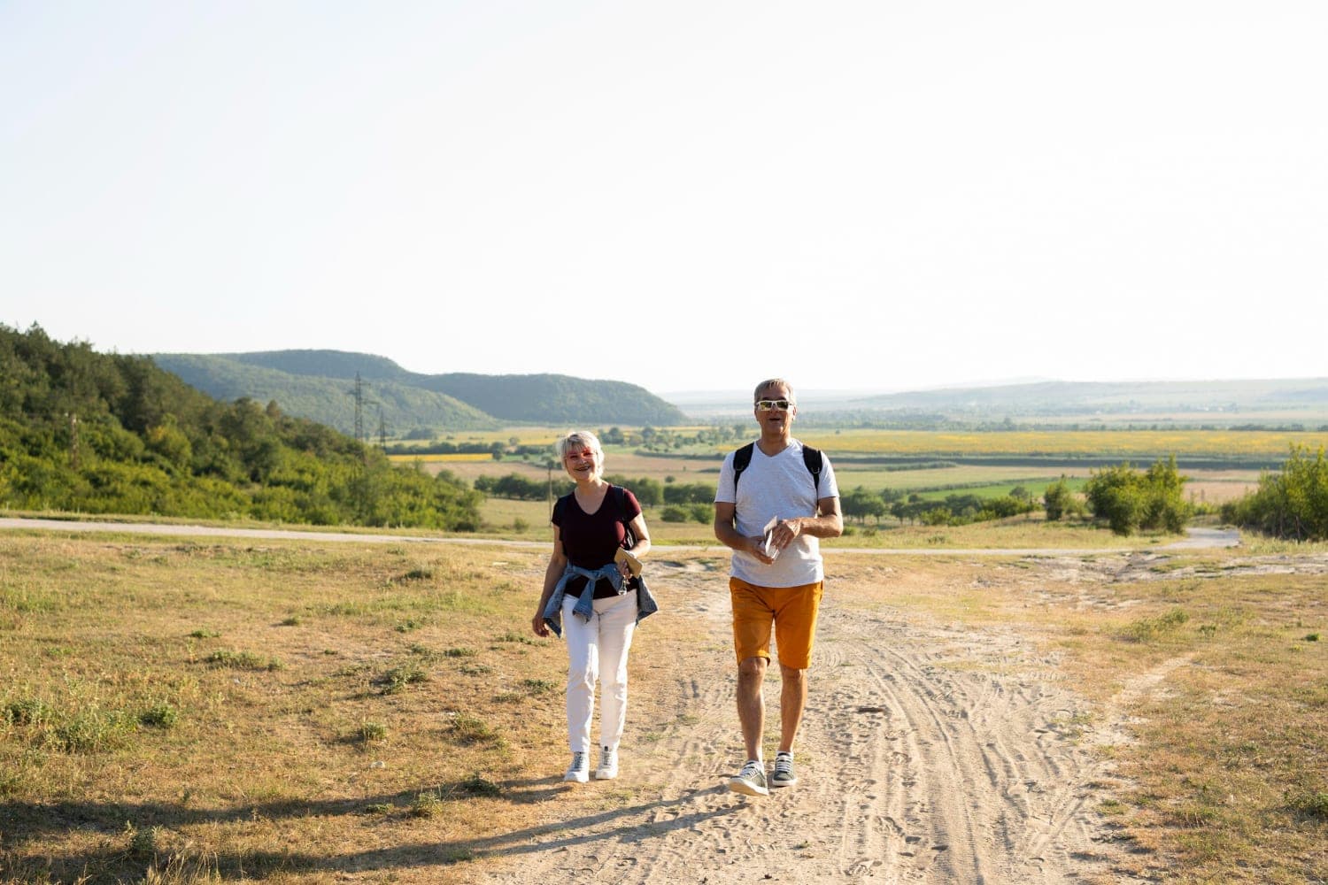 Older couple walking outdoors while planning Traditional IRA and Roth IRA retirement savings.